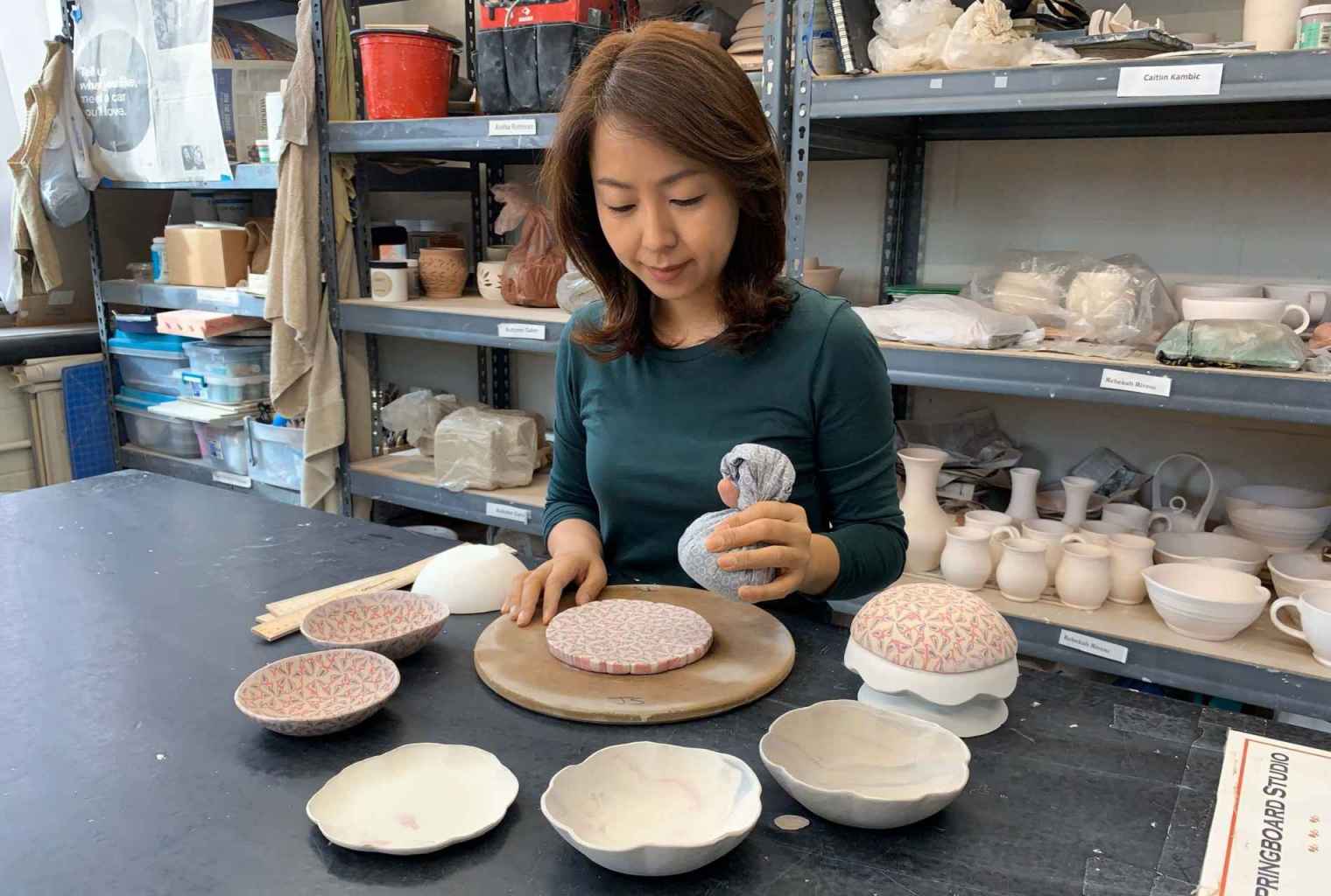 Ji SunYangs looking at a selection of pottery