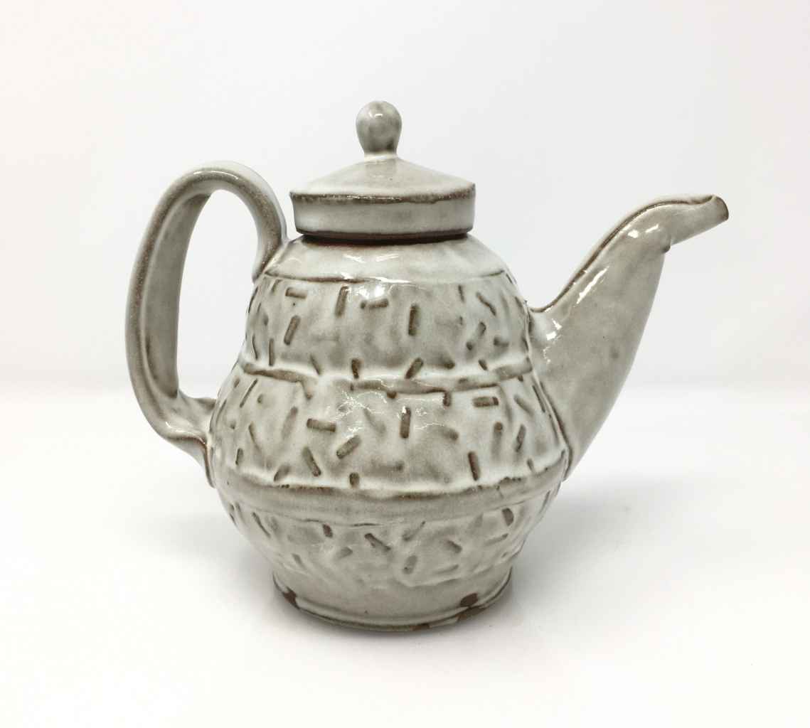 Ceramic teapot. White glaze onver tectured clay.